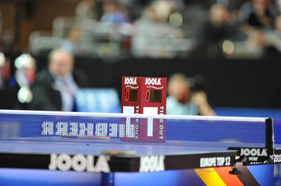 Tischtennis-Equipment mit digitalen Punkteständen 0:0 auf einer blauumrandeten Tischtennisplatte.